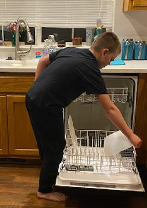 Kid chores loading dishwasher